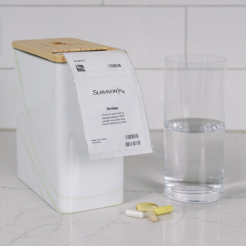White container with a label, glass of water, and small items on a tiled surface.